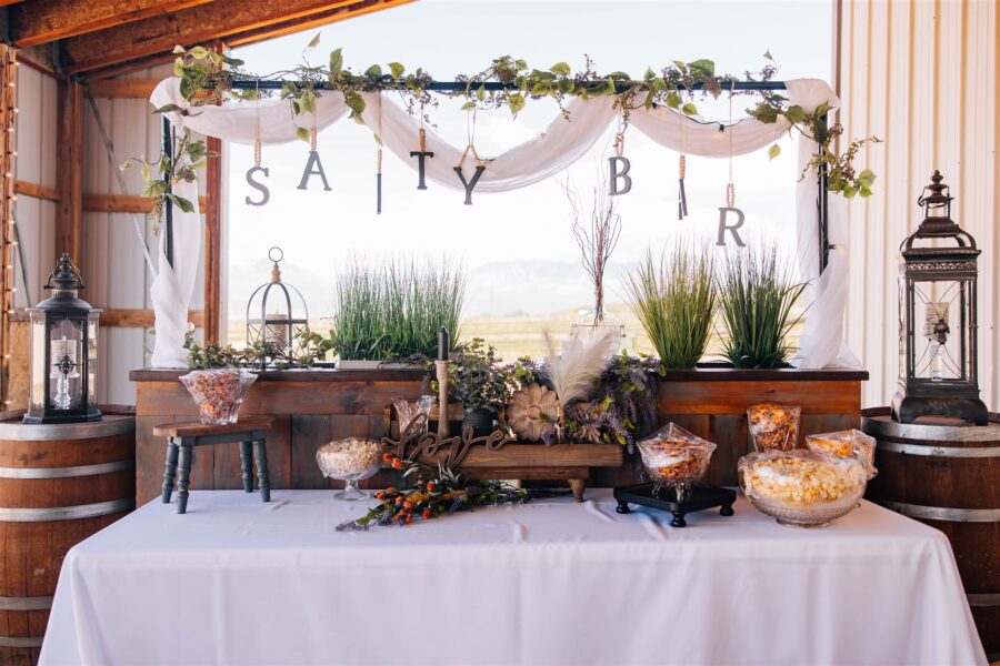 Rustic wedding snack bar display featuring decorative elements like greenery, lanterns, and a 